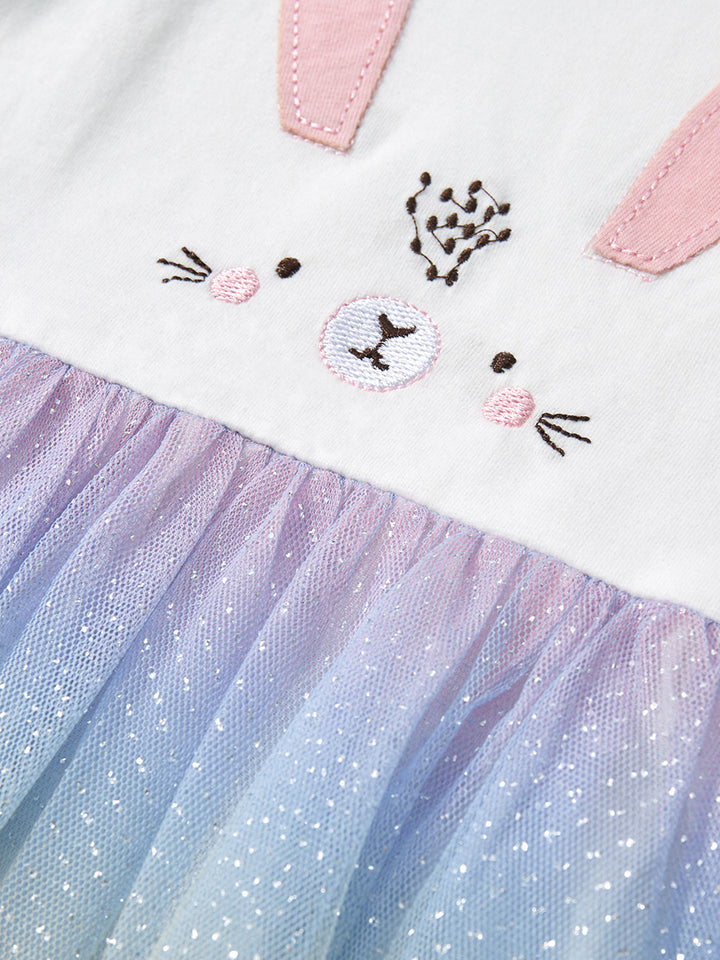Close-up of a children's outfit with a cat face design and tulle skirt.