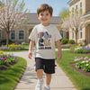 Young boy wearing dinosaur t-shirt and shorts set during outdoor play