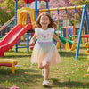 Young girl wearing Caroagi bunny rainbow tulle dress twirling in playful setting